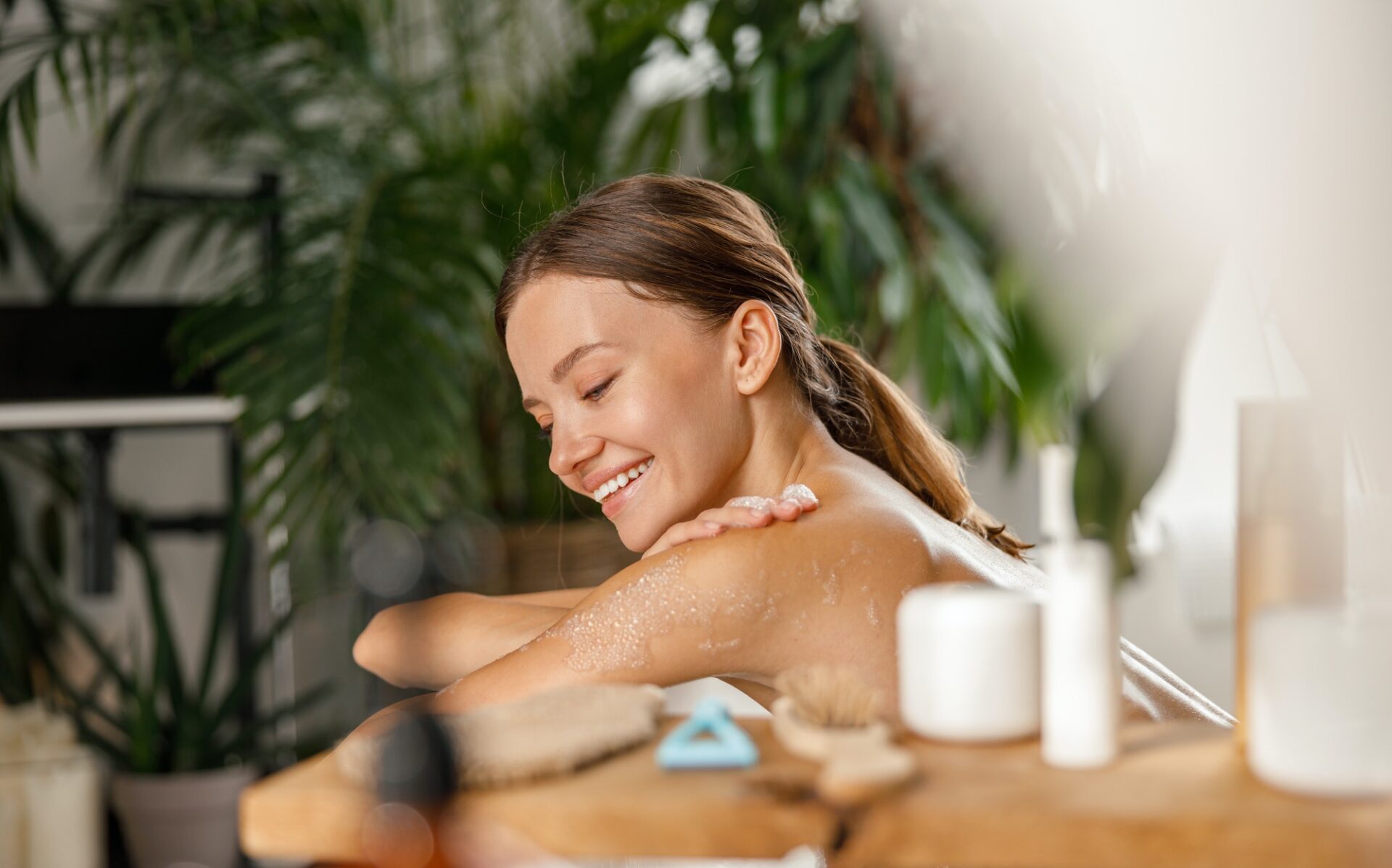 Portrait of smiling young woman bathing and taking care of her body at spa resort